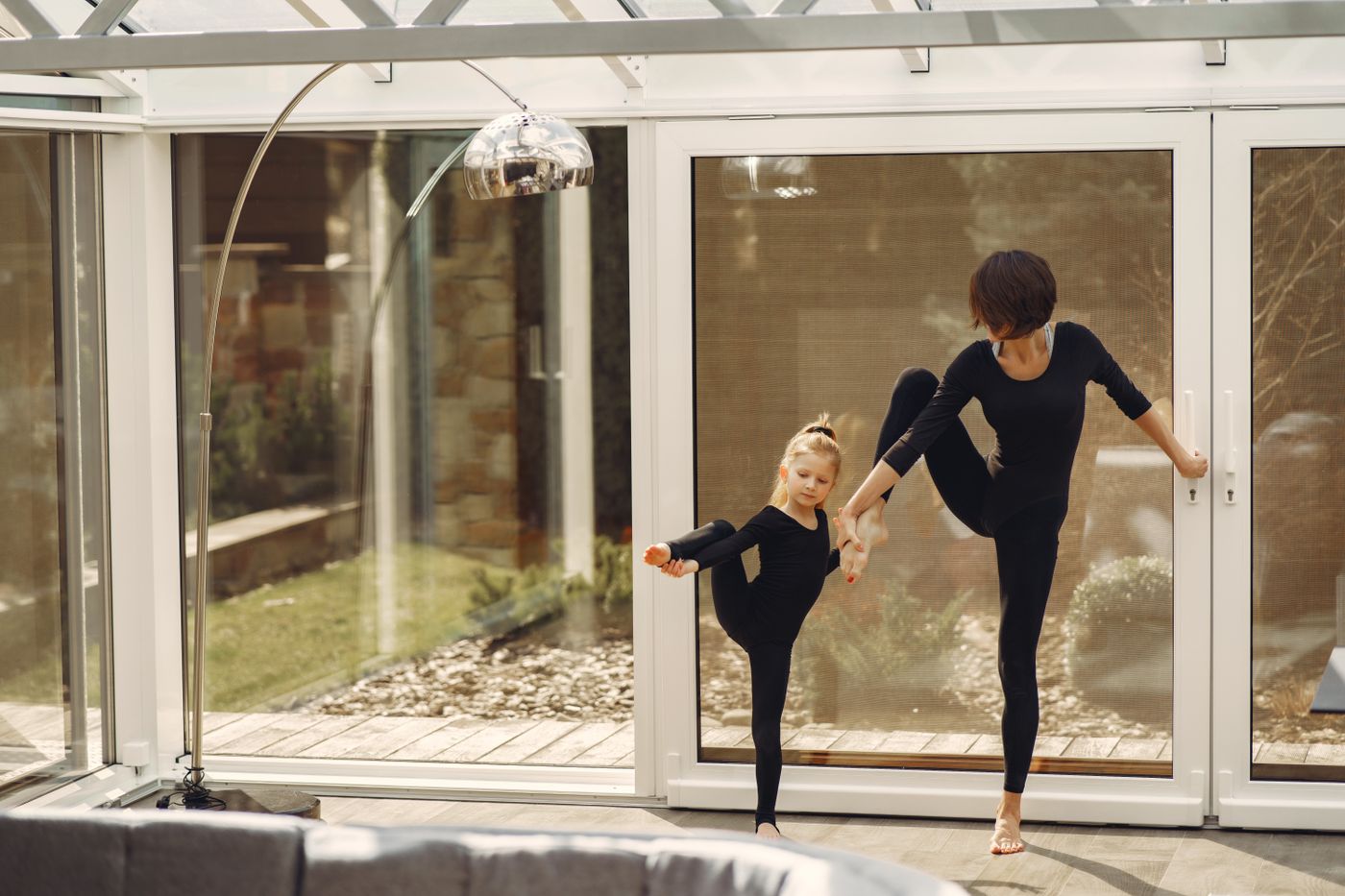 Mother and daughter practicing ballet exercises together at home